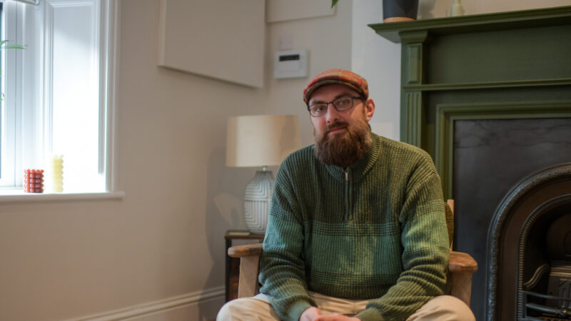 Man in flat cap sat in therapy room at James' Place