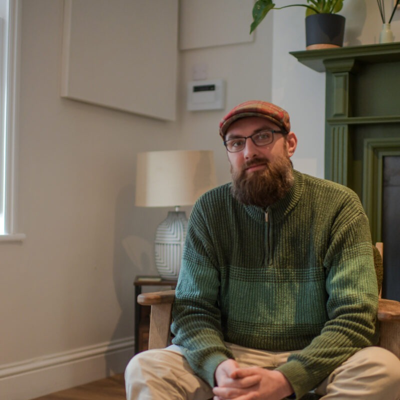 Man in flat cap sat in therapy room at James' Place