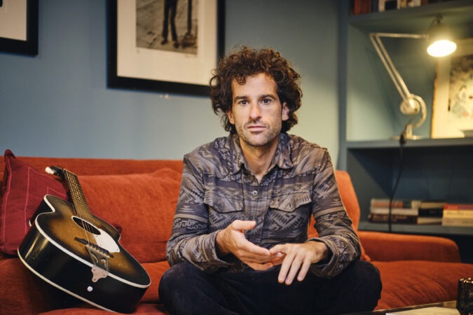 Man sitting on sofa looking at camera