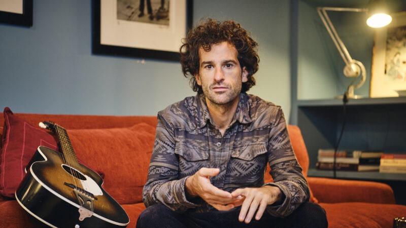 Man sitting on sofa looking at camera