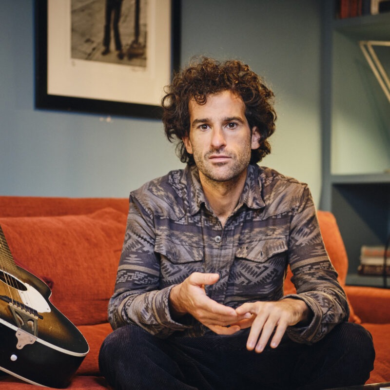 Man sitting on sofa looking at camera